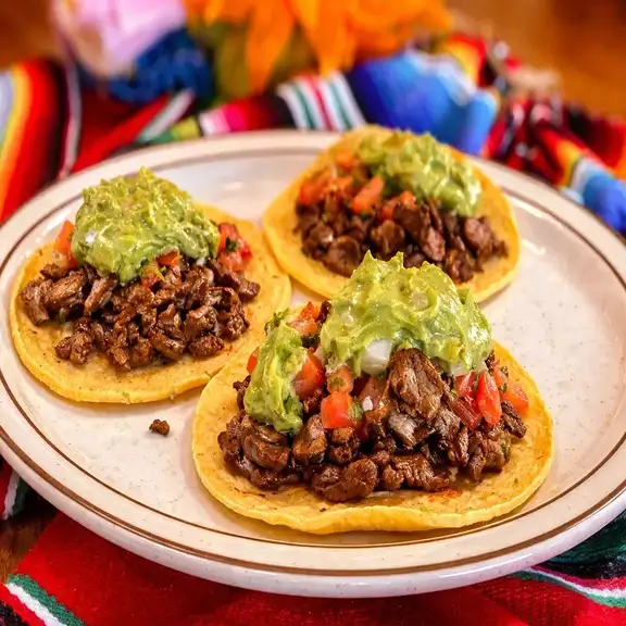Street tacos topped with guacamole and grilled meat at Javier's Authentic Mexican Food Los Angeles CA